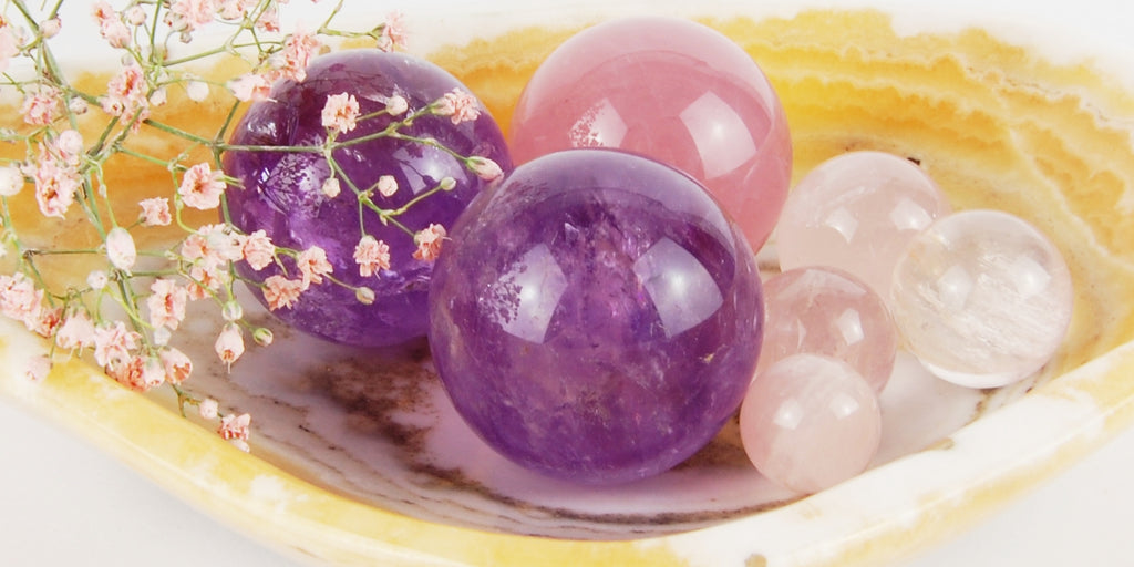 Pierres de décoration : sphères en améthyste et quartz rose dans un bol en aragonite